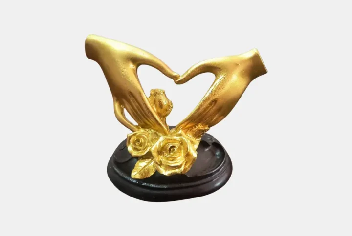 Celebrate love and togetherness with this elegant Golden Love Hand Heart Showpiece. Crafted from durable resin material, this romantic sculpture features two beautifully sculpted golden hands forming a heart shape, symbolizing affection, unity, and everlasting bonds. The base is accented with delicate roses, making it perfect as a gift or a stylish décor item.