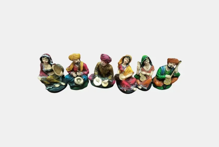 Celebrate the vibrant essence of Rajasthan with this stunning Rajasthani Musical Band Showpiece Set from Pitstop Mart. This handcrafted set features six beautifully dressed traditional male and female musicians, each playing classical Indian instruments like the dholak, manjira, shehnai, and more